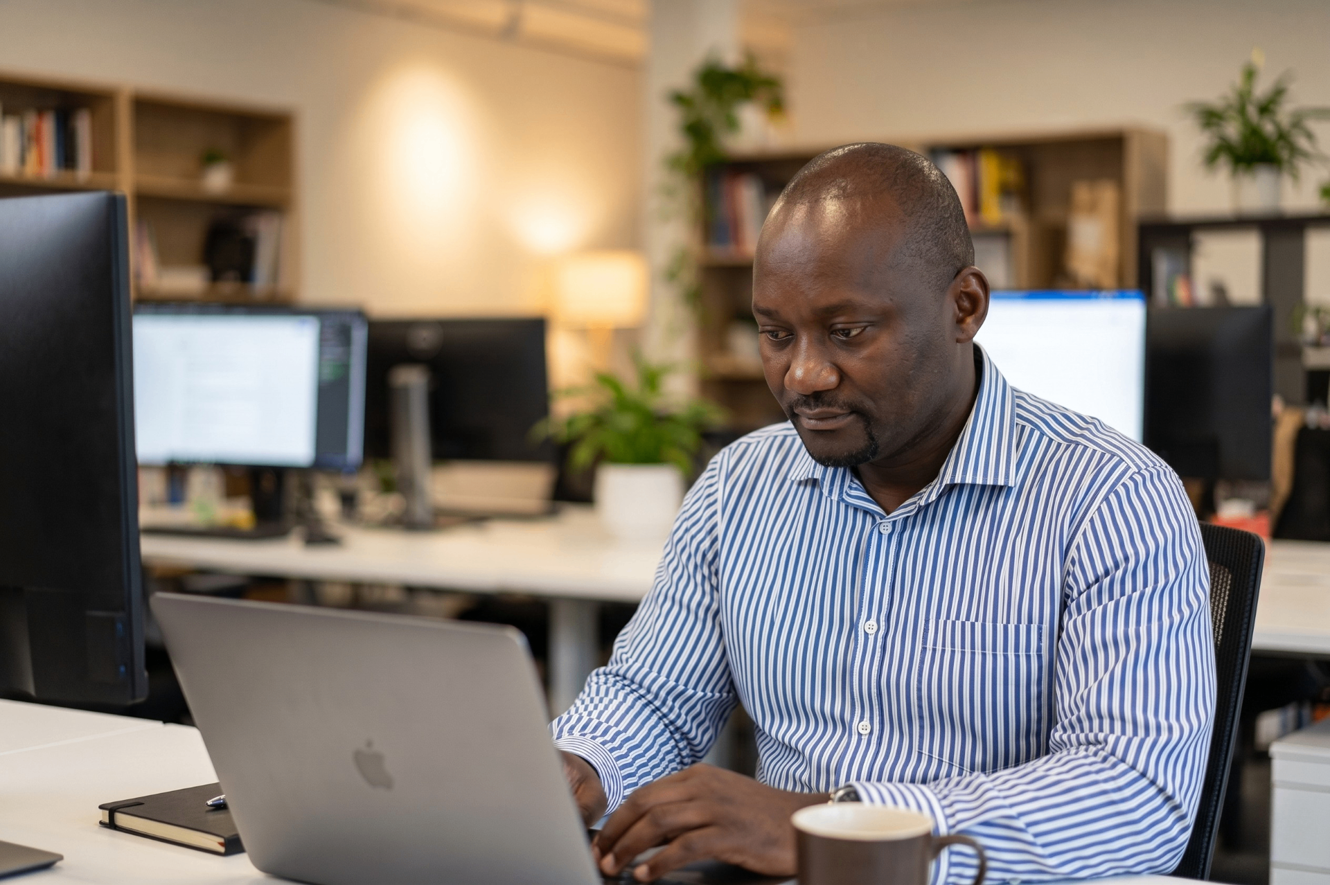 Software developer working on a laptop in a modern office